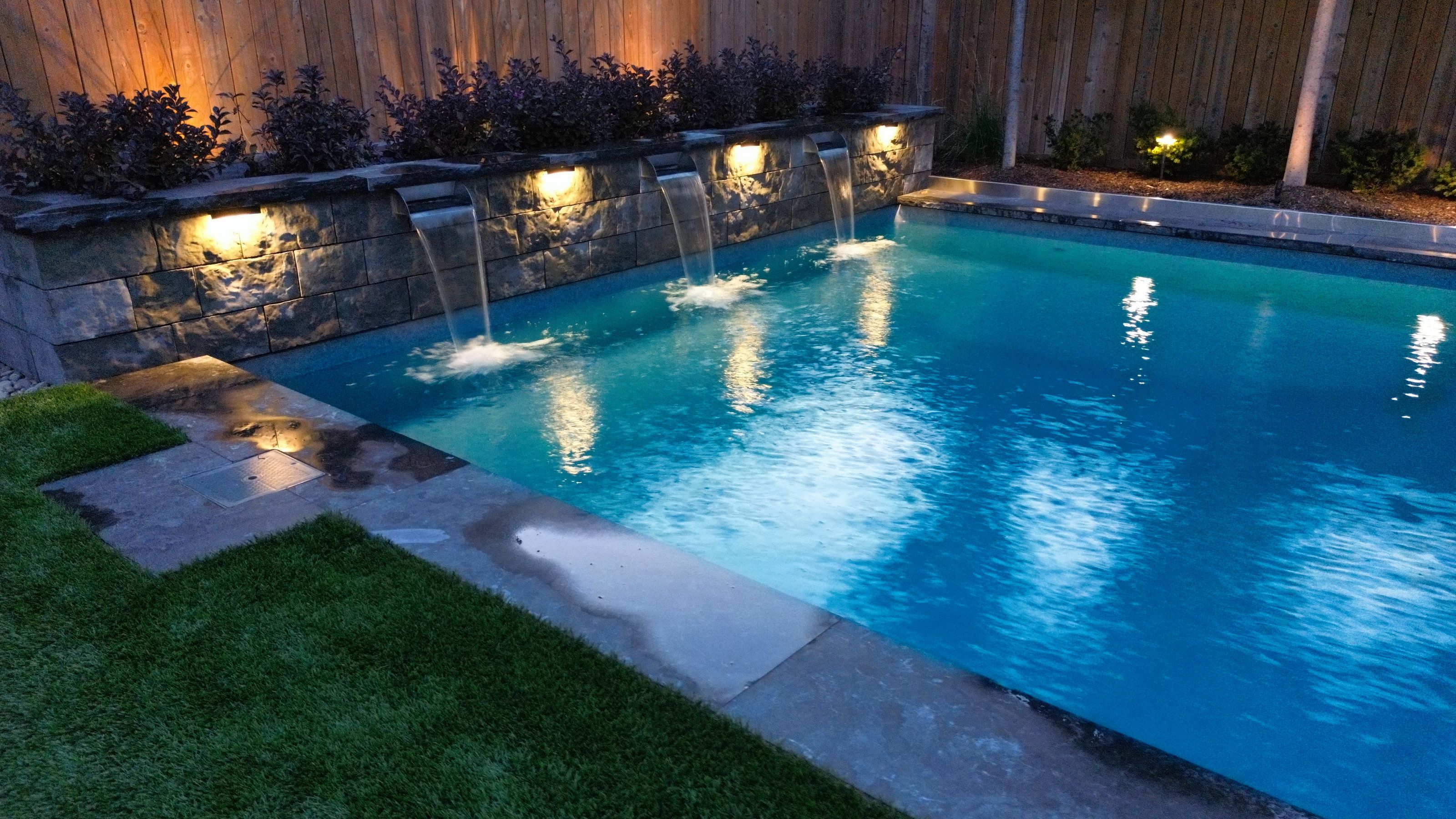 Illuminated waterfall at night with landscape lighting