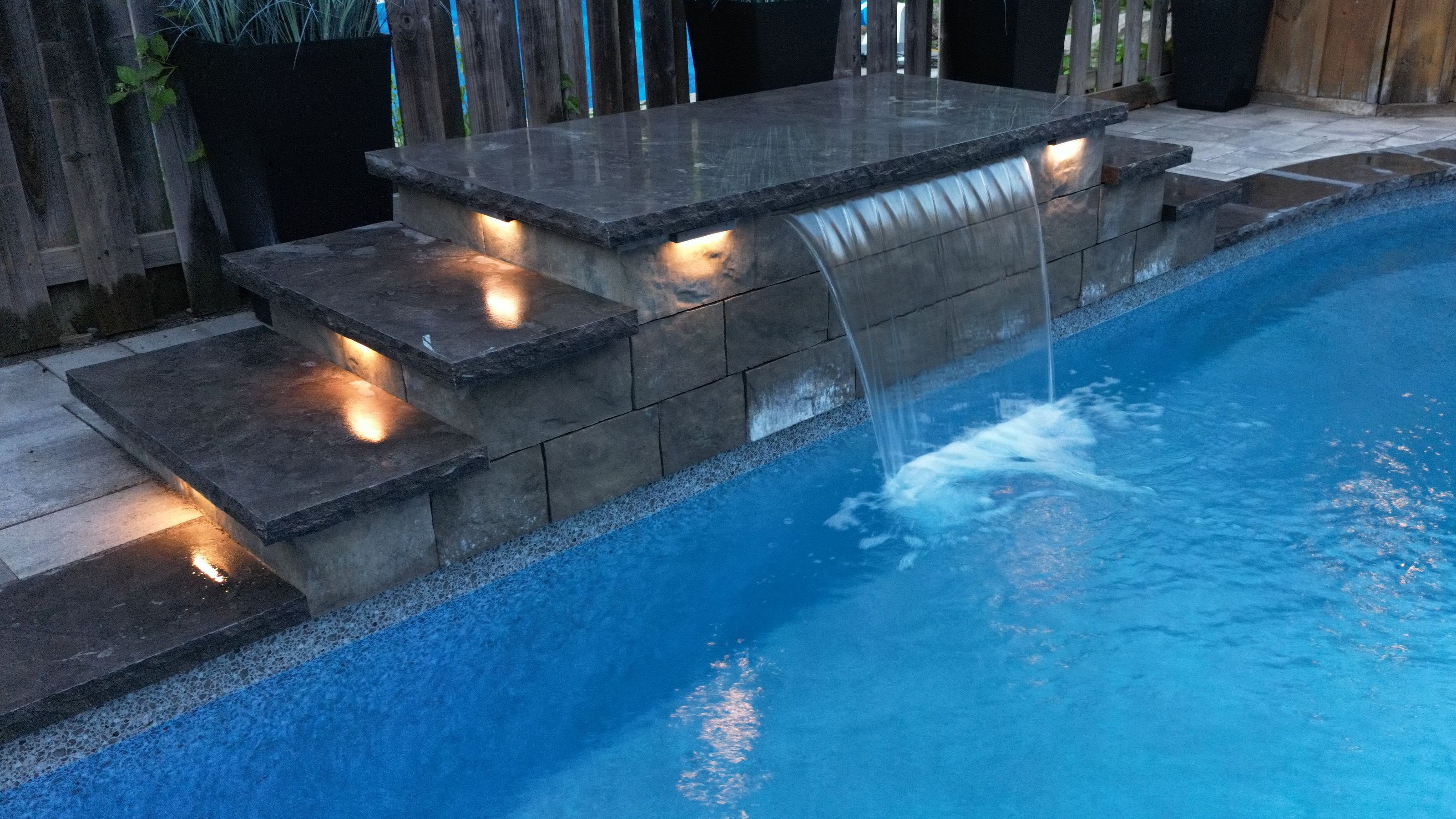 Waterfall feature with landscape lighting